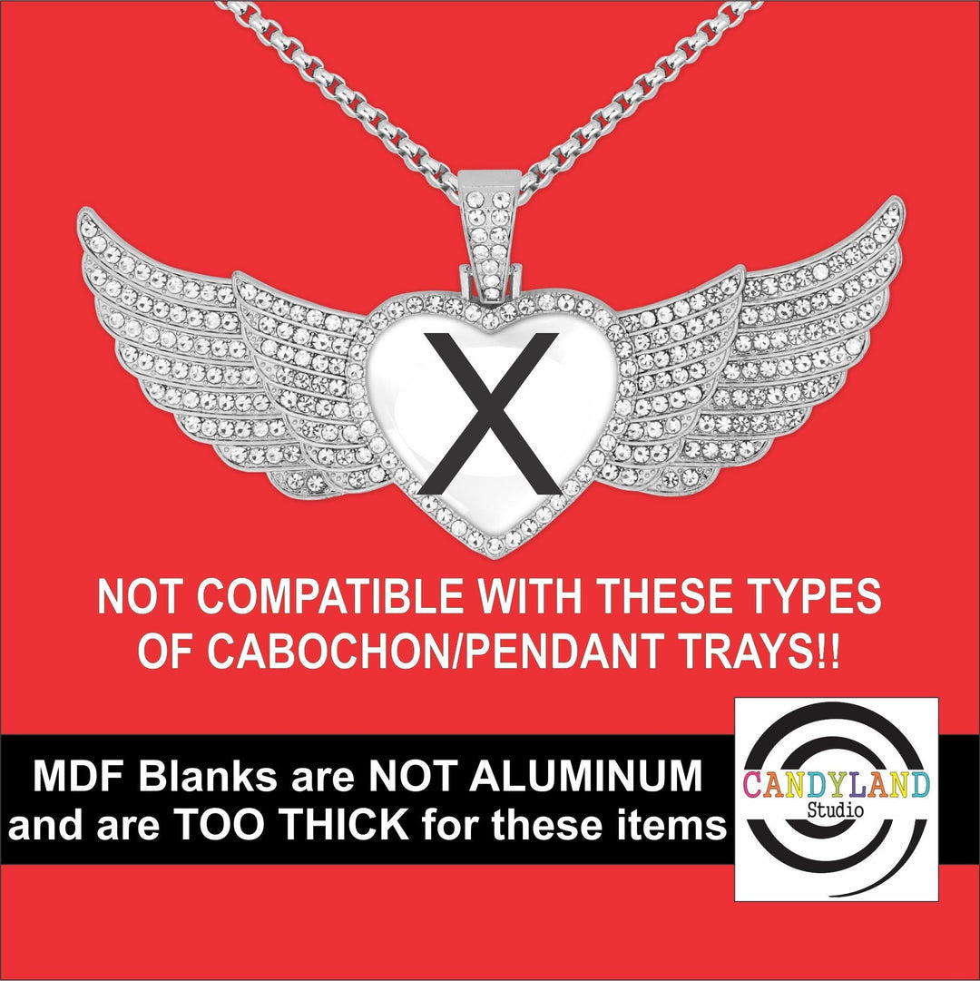 a heart-shaped pendant with wings, set against a red background. The pendant is adorned with sparkling diamonds and has a large "X" in the center. The image also includes text that warns that the pendant is not compatible with certain types of cabochon/pendant trays and that MDF (Master Dozen) blanks are not suitable for these items due to their thickness.